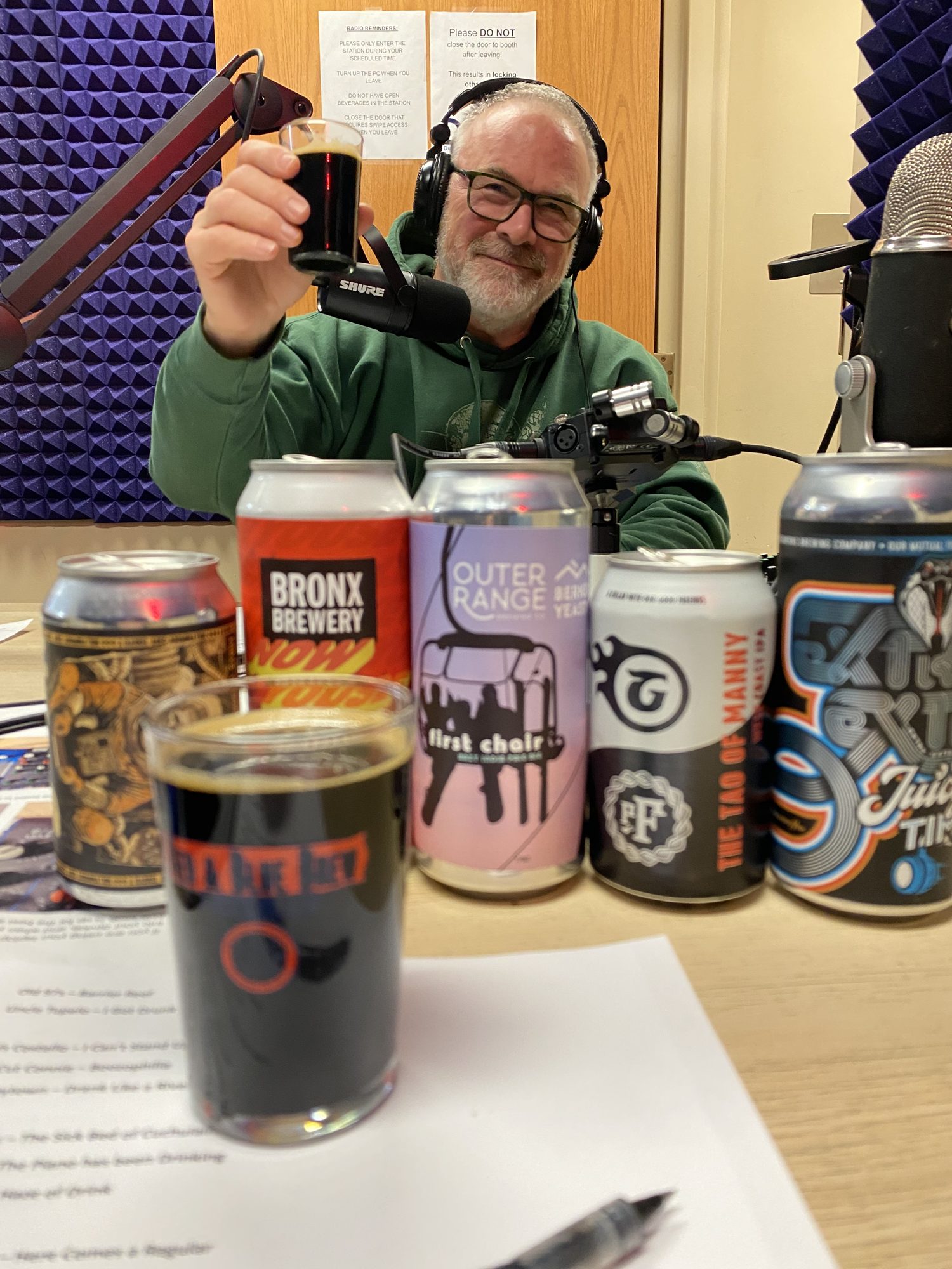 Raising a dark pour behind the beer lineup